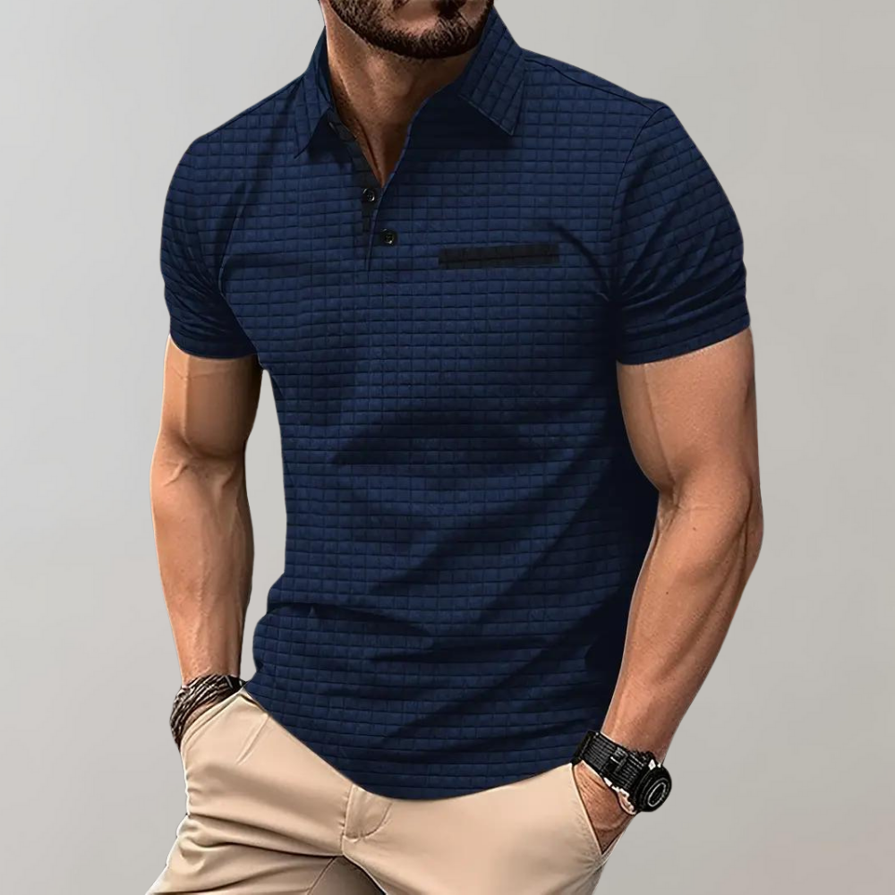 Mann in dunkelblauem, kariertem Poloshirt und beigen Hosen, trägt Armbanduhr. Modetrend Herrenbekleidung, stilvolles Freizeitoutfit.