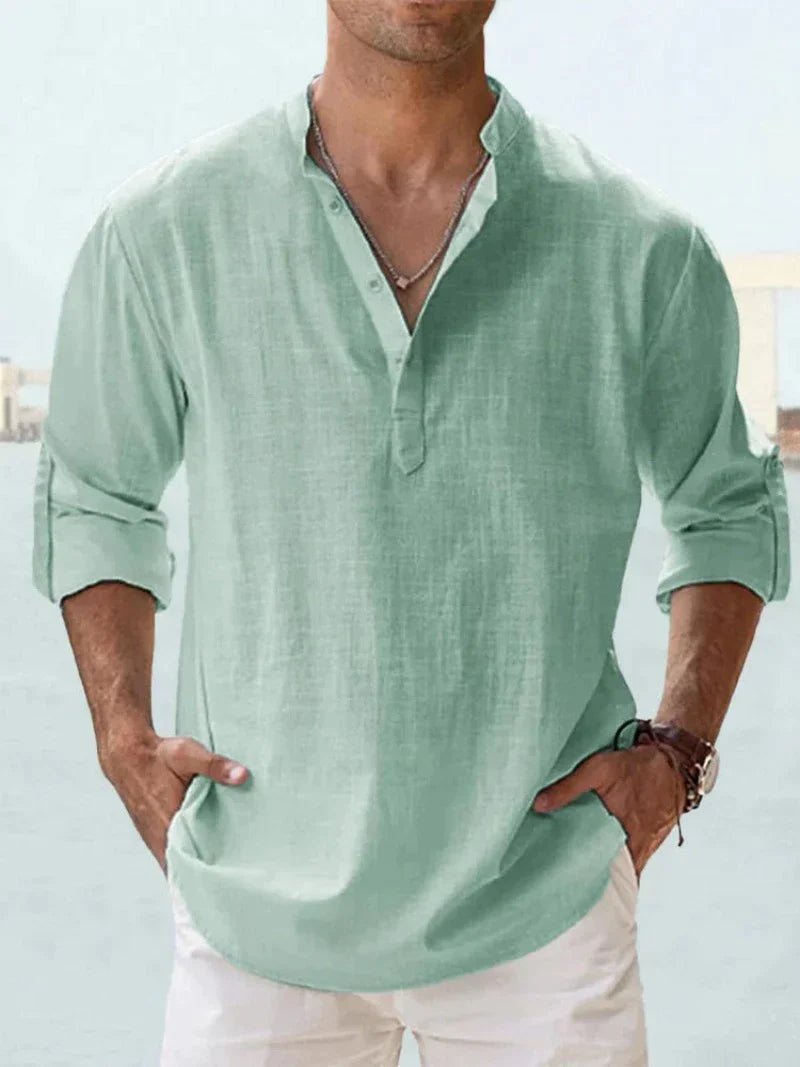 Grünes Leinenhemd für Herren mit Stehkragen und Knopfleiste, lässig und stilvoll, ideal für Sommermode. Perfekt kombiniert mit weißen Hosen.
