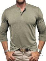 Mann in olivgrünem Henley-Shirt mit langen Ärmeln, beige Hose und Lederarmbändern. Modischer Freizeitlook für Herren.
