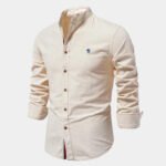 Beiges Herrenhemd mit Stehkragen, langen Ärmeln und braunen Knöpfen. Elegantes Design, ideal für Business und Freizeit. Baumwollstoff.
