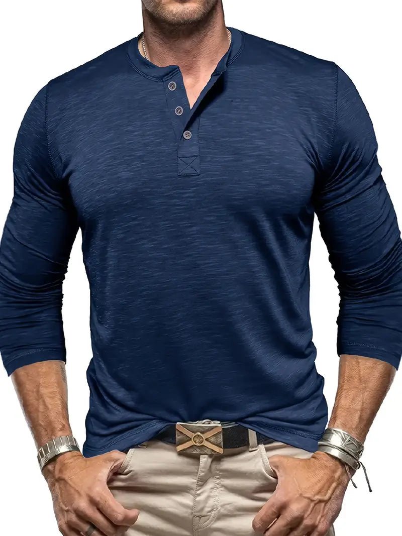 Mann in dunkelblauem Henley-Shirt mit langen Ärmeln und beigen Hosen. Modischer Freizeitlook, ideal für Herrenmode und Stil.